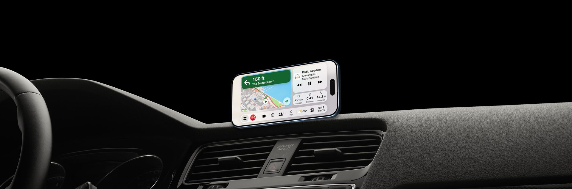 An iPhone running CarOS on a magnetic mount on a car dashboard, at night: turn-by-turn directions, the radio and the trip on one screen